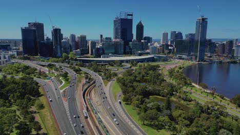 Aerial-drone-backward-moving-shot-over-freeway-or-highway-with-traffic-movement-in-Perth,-Western-Australia-on-a-sunny-day