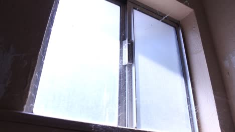 la luz de la ventana abandonada brilla a través de las telarañas.