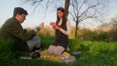 friends playing cards in a park