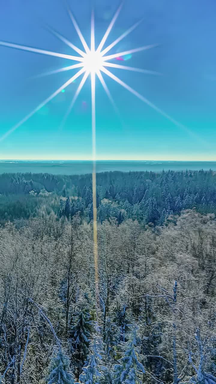 The sun slides past a blue sky over a winter landscape