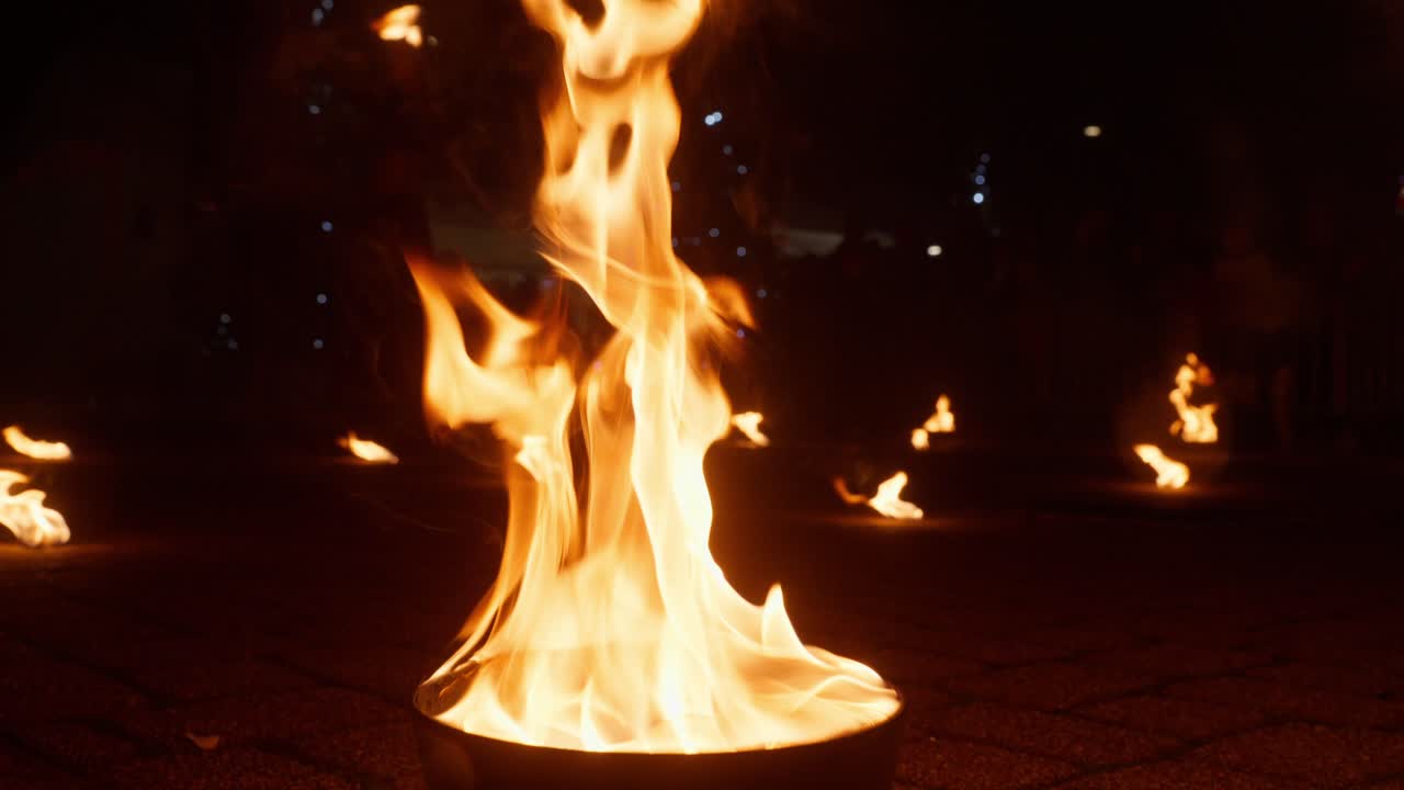 Slow motion fire performance at night festival with flames sparks and mystical mood