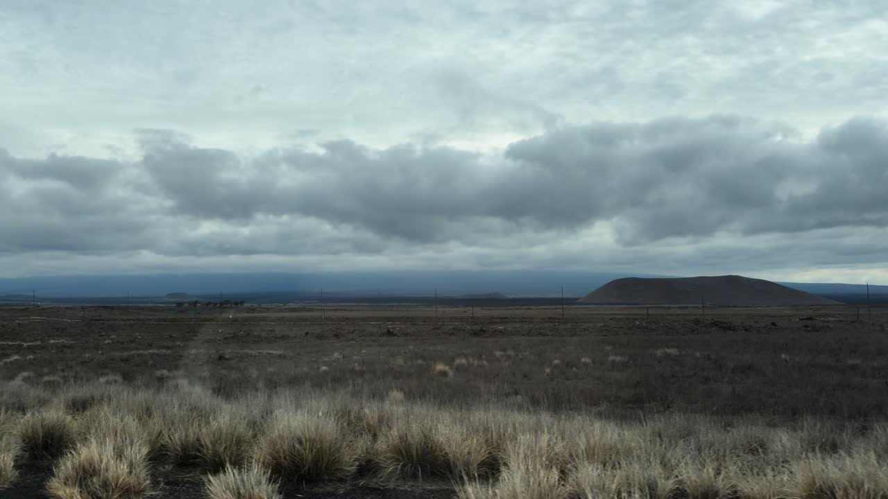 Fast-moving foreground reveals arid plains and a distant hill near Kawaihae
