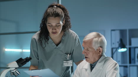 senior scientist working with female assistant in lab