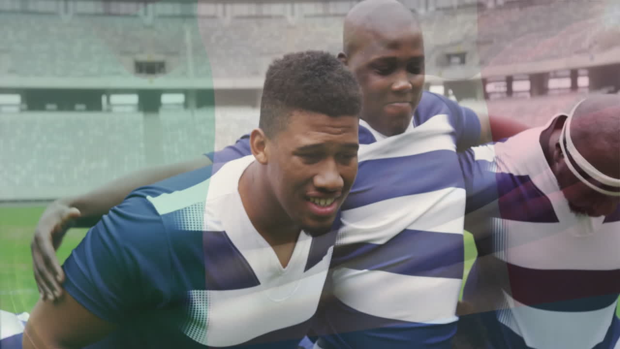 Huddling on field, rugby players in striped jerseys planning strategy together