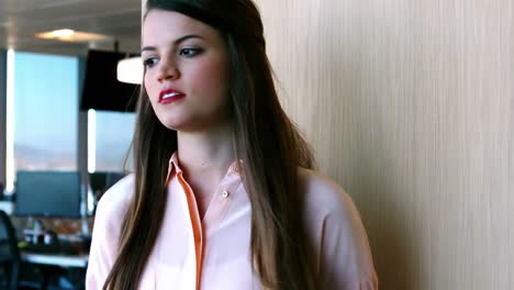 Upset-woman-leaning-against-the-wooden-wall-in-the-office