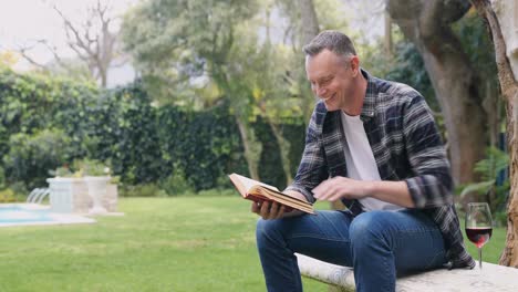 Mature-man-reading-a-book-in-the-garden-4k