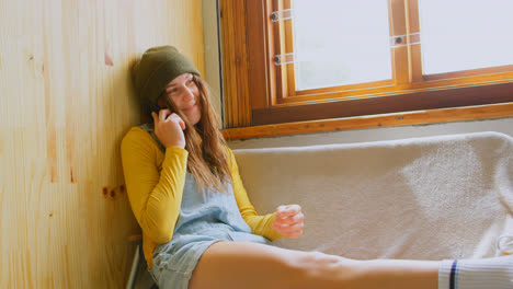 Front-view-of-young-caucasian-woman-talking-on-mobile-phone-in-a-workshop-4k