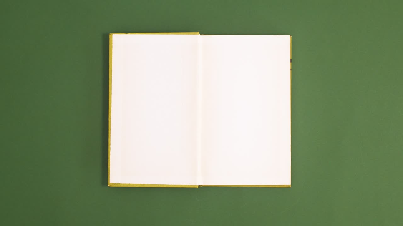 Light Green vintage hardcover book appear and open with copy space on dark green background. Stop motion flat lay