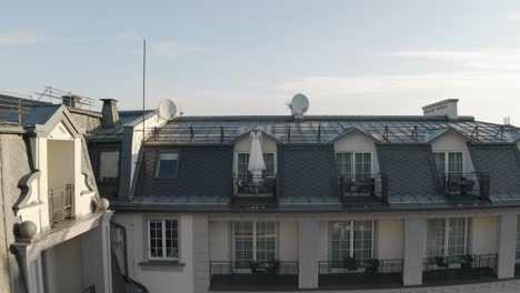 white wedding dress hangs on special hanger in doorway of balcony of luxury house, aerial view