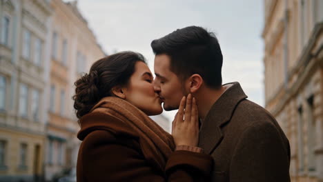 couple kissing affectionately on a city street