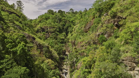 Ella-Sri-Lanka-Vista-Aérea-V41-A-Vista-De-Pájaro-Toma-De-Elevación-Con-Dron-Que-Captura-Las-Cataratas-Superiores-De-Ravana-Escondidas-En-El-Aislado-Y-Verde-Valle-Rodeado-De-Frondosos-Y-Densos-Bosques---Filmado-Con-Mavic-3-Cine---Abril-De-2023