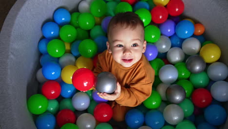 smiling baby boy in colorful ball pit