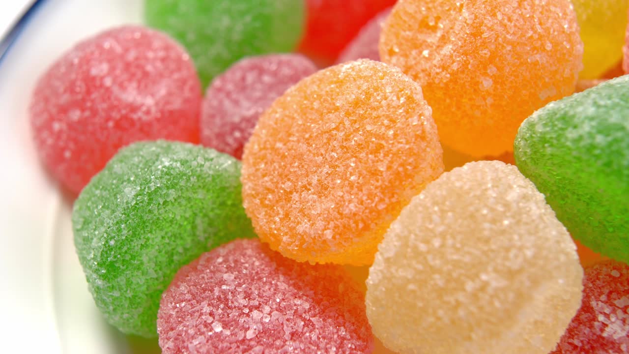 caramelos de mermelada azucarados variados en un plato blanco. forma redonda de jalea confitada translúcida