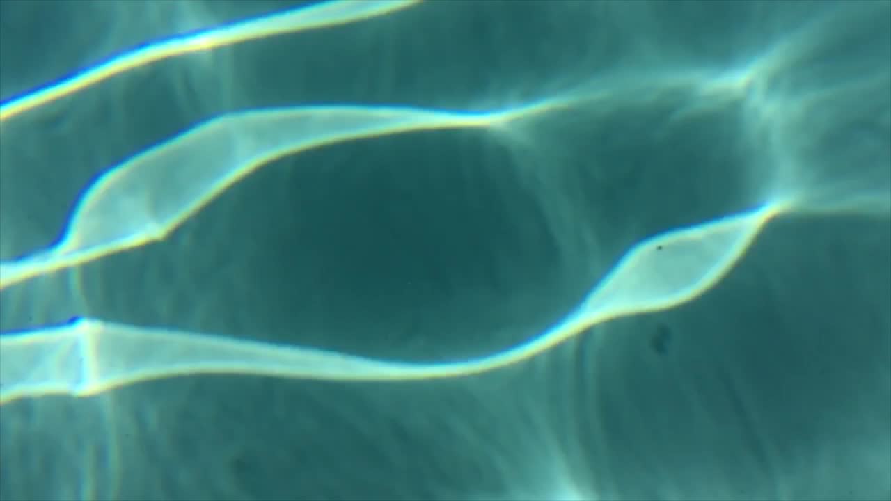 cáusticos fríos de la luz de la piscina golpeando el agua