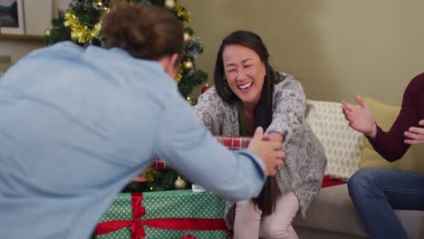 happy diverse group of friends sharing with presents at christmas time