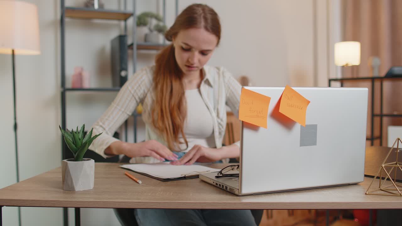 Freelancer adulta nervosa confusa dal caricamento di un grande lavoro di routine sul portatile in un ufficio domestico al chiuso