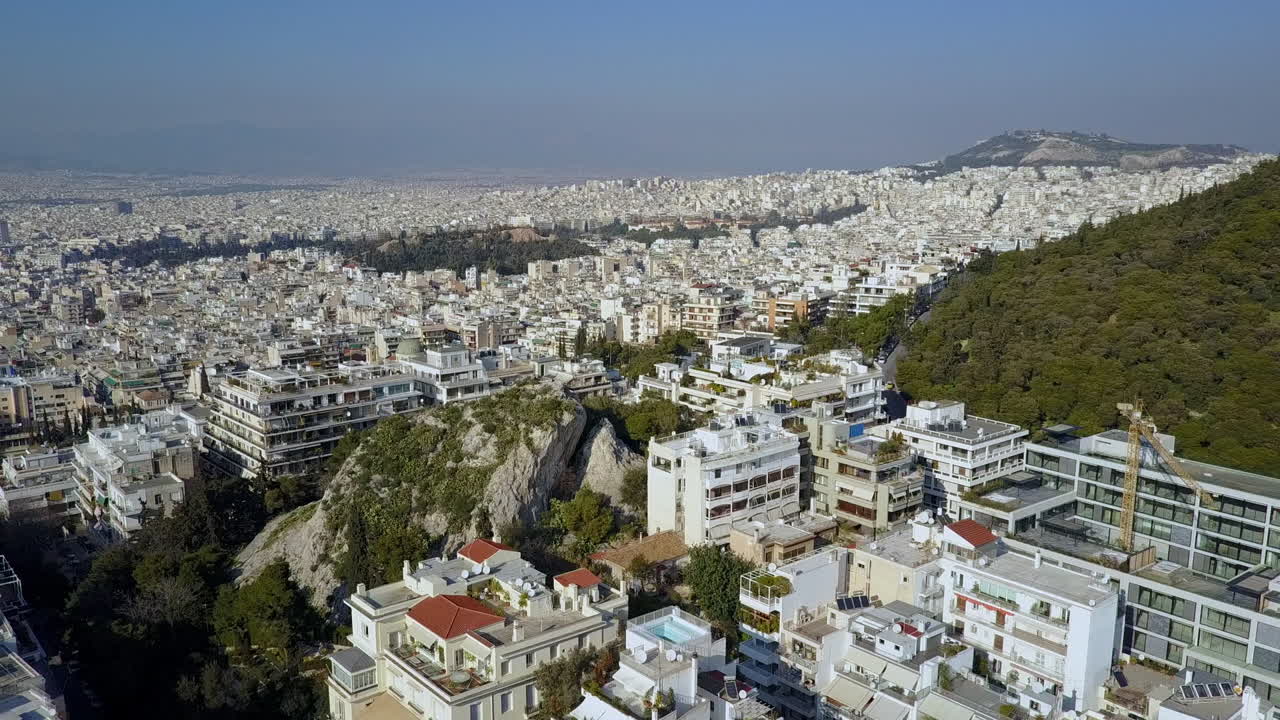 Aerial drone shot rising over Athens Greece in late afternoon, 4K.
