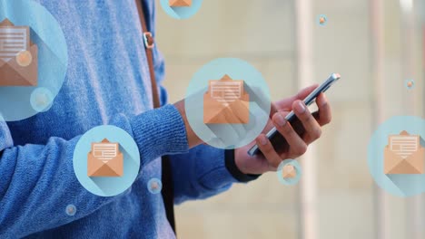 Animation of mail icons over midsection of biracial man using smartphone