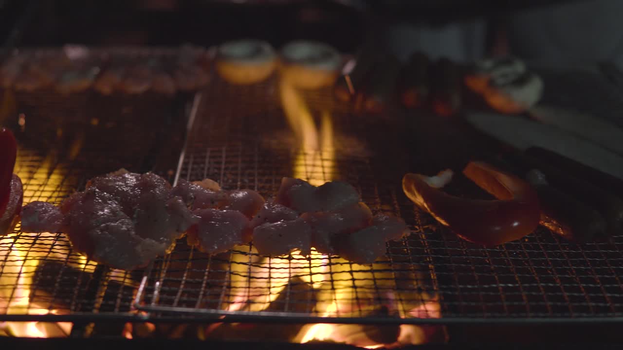 asar champiñones, salchichas, pollo, berenjenas, en una barbacoa frente a la casa en un jardín.
