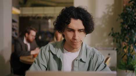 a young man working on his laptop at a cafe