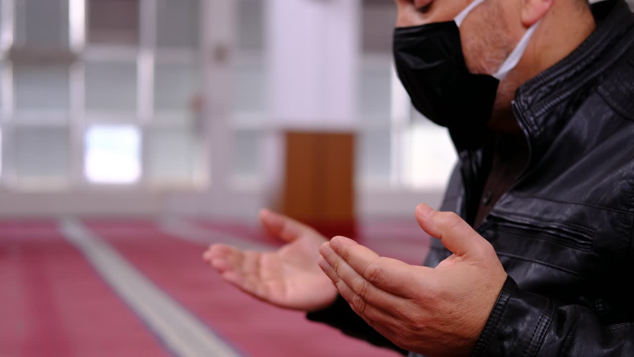 손을 들고 모스크에서 기도하는 남자