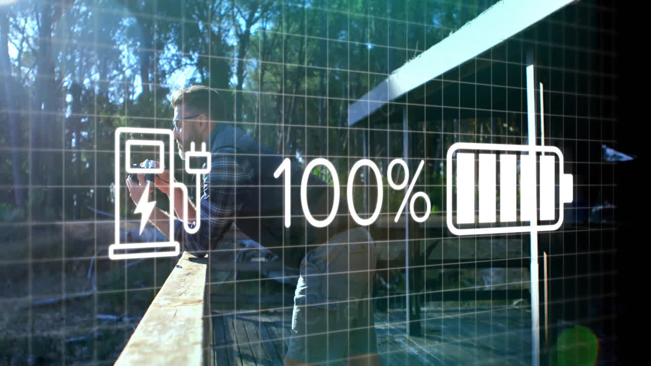 Mature man leaning on deck snapping forest with camera, displaying EV charger and battery icons