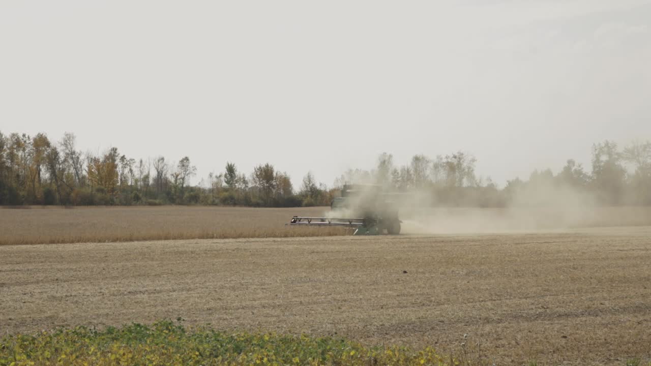 tierras de cultivo polvorientas con tractor y cosechadora en funcionamiento
