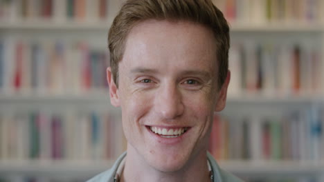 close-up-portrait-young-red-head-man-student-laughing-enjoying-relaxed-college-lifestyle-in-bookshelf-background