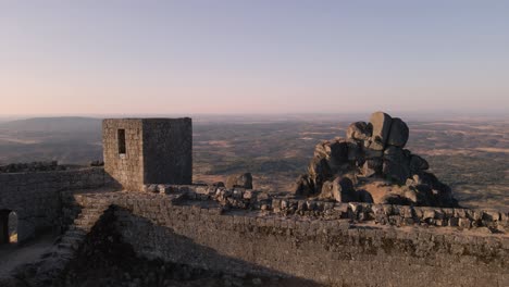 drone flying over monsanto ruins viewpoint at sunrise, portugal