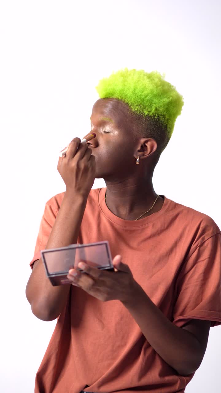 Uomo con capelli verdi che si trucca