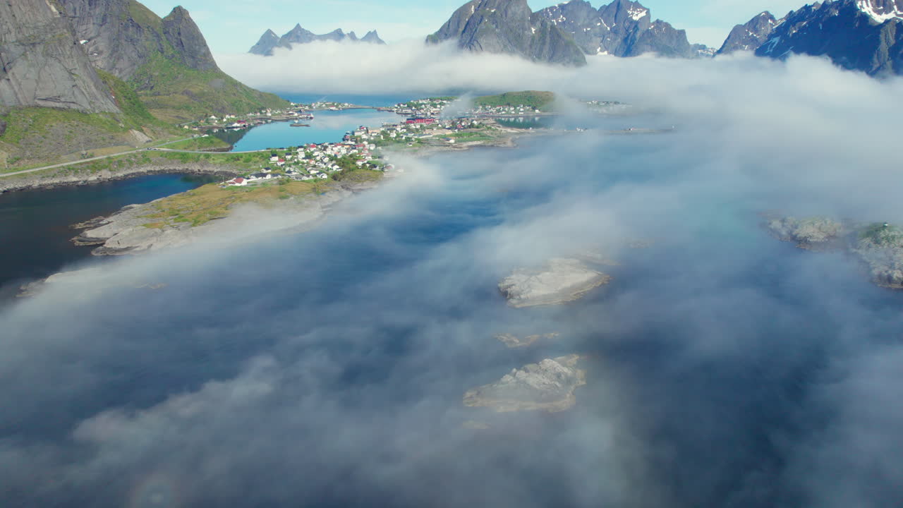 islas lofoten, noruega: fotografía aérea sobre montañas nubladas e islotes pequeños y hacia la ciudad pesquera de reine
