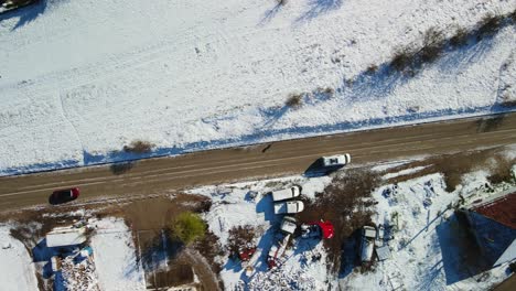 Luftaufnahme-Eines-Vans,-Der-An-Einem-Sonnigen-Wintertag-Auf-Einer-Landstraße-Mit-Verschneiter-Landschaft-Fährt,-Dalmatien,-Kroatien