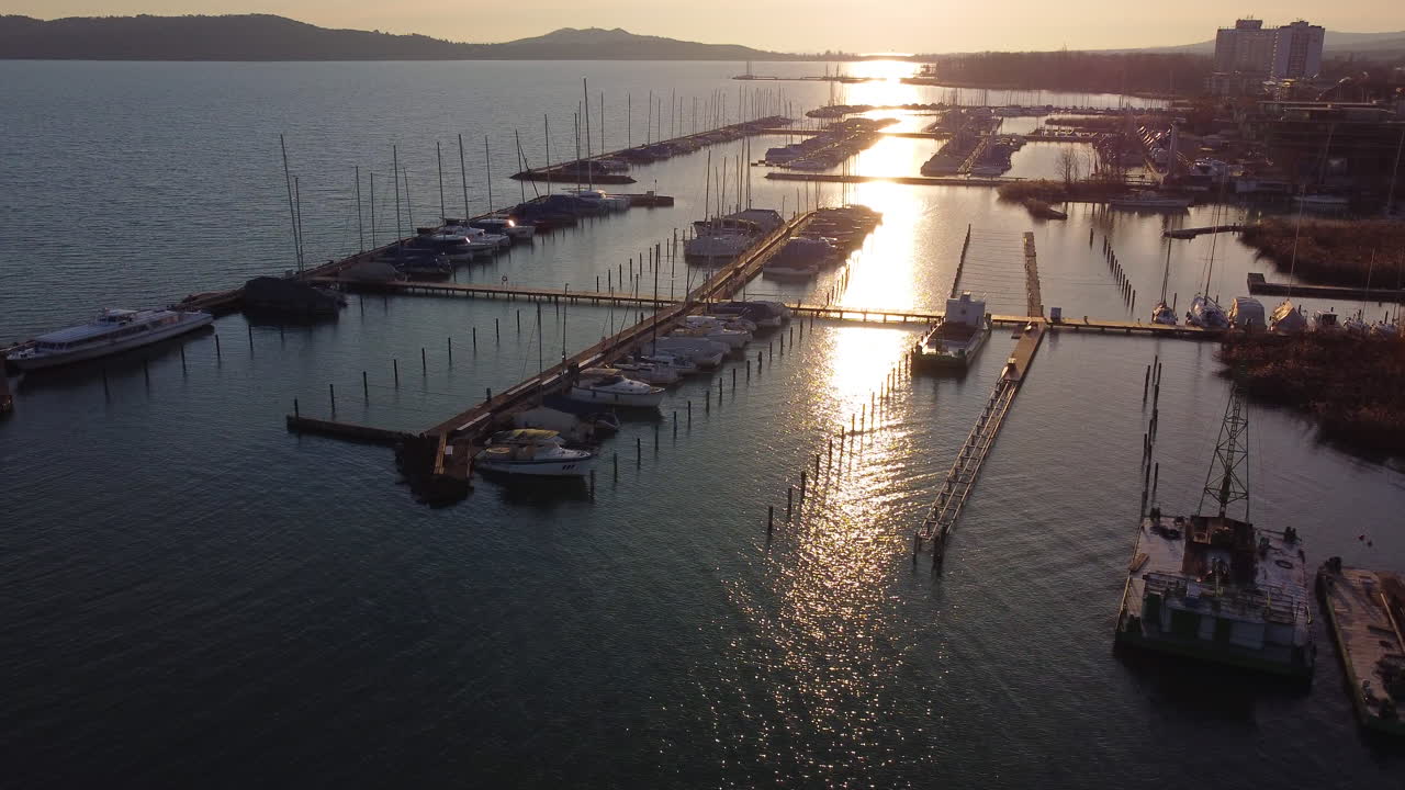 Reflective sunset light over Balatonfured docked boats seen from above during golden hour