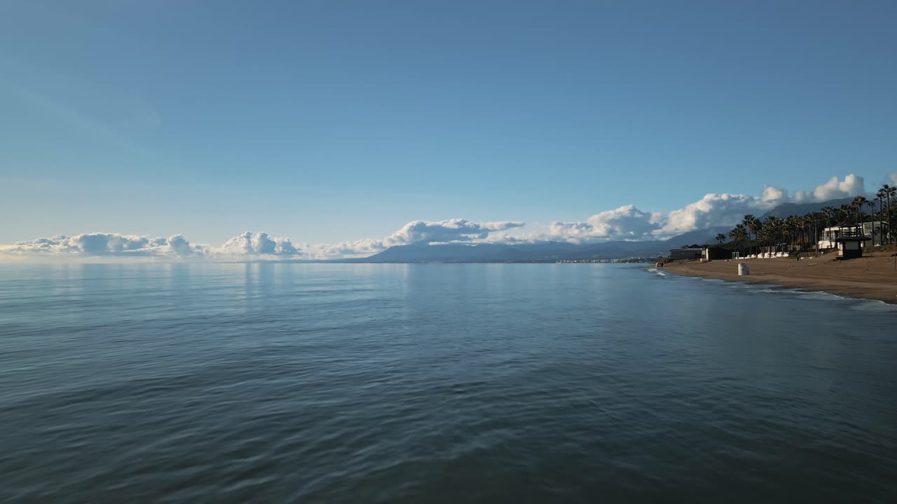 뒤로 움직이는 스페인 마르베야 해안선 근처의 부드러운 파도의 공중 전망