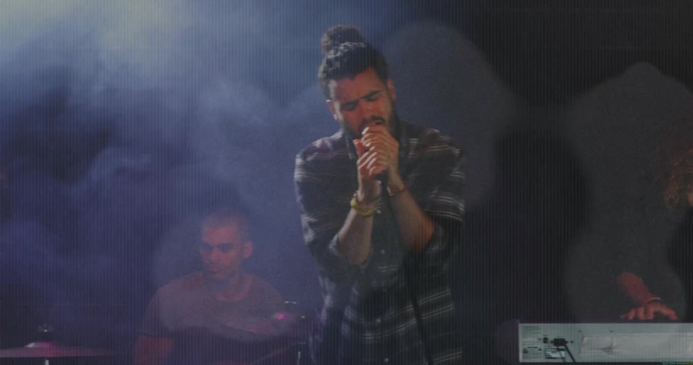 Lead singer stepping forward on band cue in music performance, moving center and singing into mic