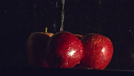 water droplets falling onto red apple