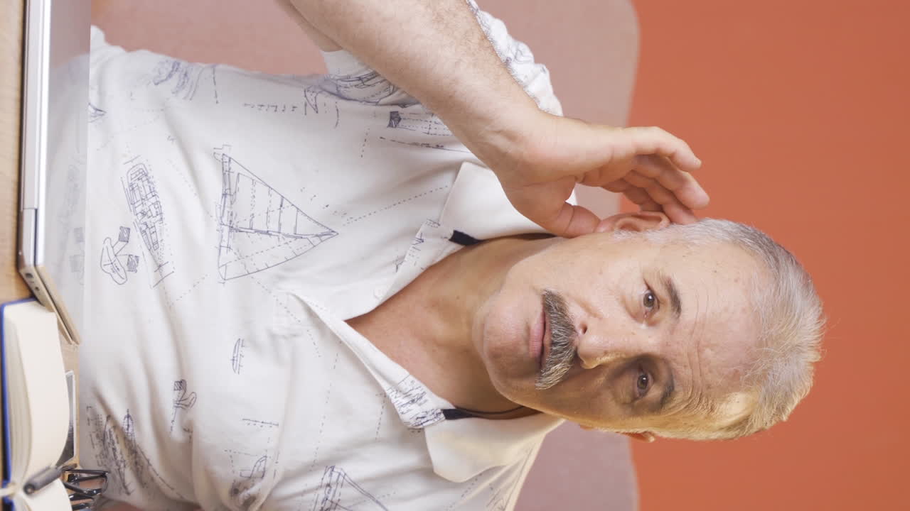 Vertical video of A old man with a hearing problem.