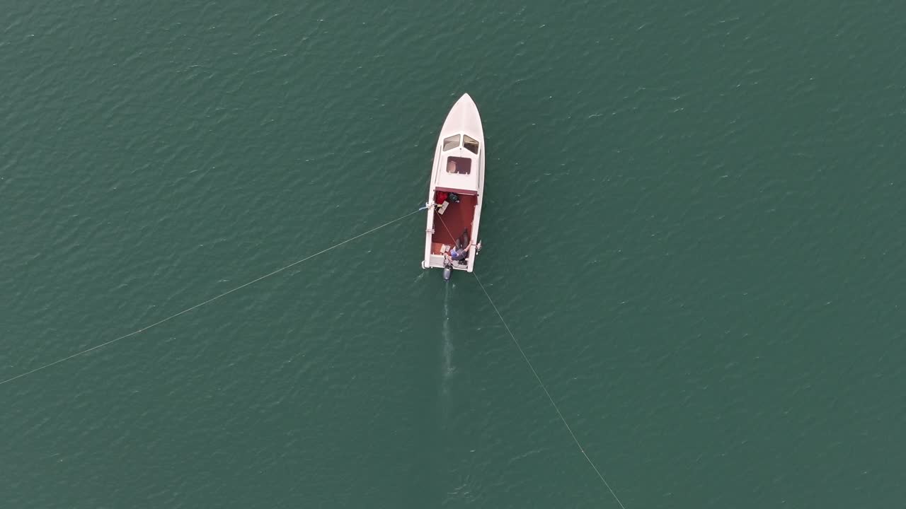 Walensee'nin zümrüt sularında yalnız bir tekne, İsviçre dinginliği - havadan kuşbakışı görünüm.