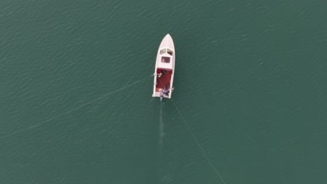 Barco-Solitario-En-Las-Aguas-Color-Esmeralda-De-Walensee,-Serenit-Suizo---Vista-Aérea-De-Arriba-Hacia-Abajo