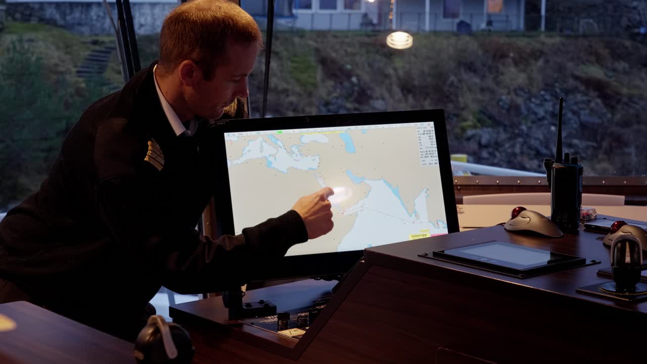 el capitán mostrando la ruta al mar rojo en una carta electrónica, nervioso y mostrando la explosión con las manos