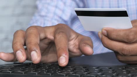 person using credit card and keyboard for online payment.