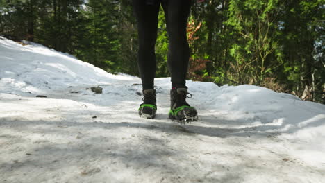 hiker boots with anti-skid crampons walking in the snowy track in tatra mountains. - closeup shot