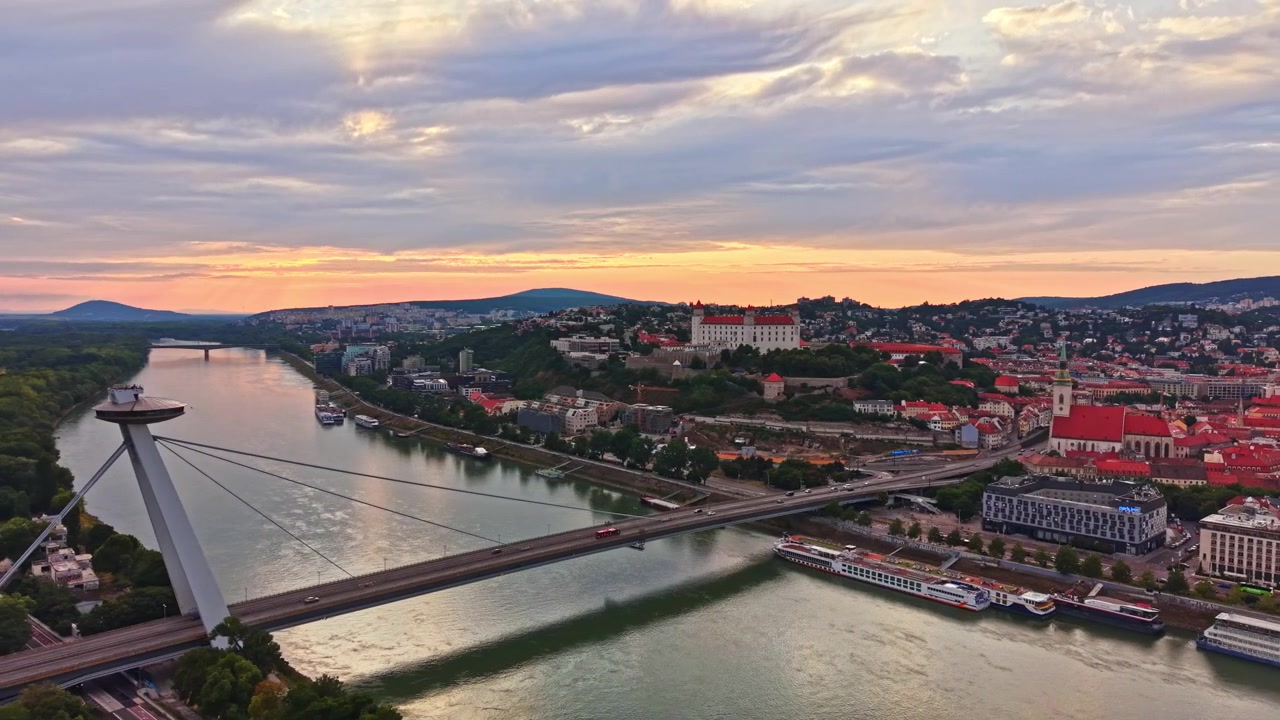 Udsigt over byen med flod og bygninger ved solnedgang i Bratislava