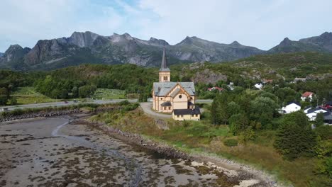 vista aérea de una iglesia nórdica en lofoten, noruega, enmarcada por majestuosas montañas