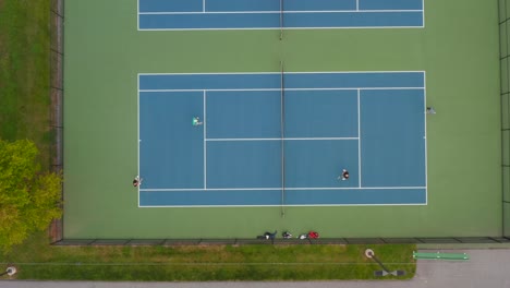 top down aerial of doubles playing tennis at court