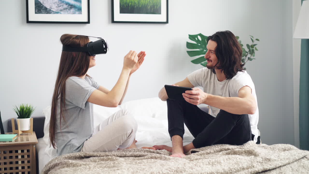 Couple Relaxing and Playing VR Games in Bedroom