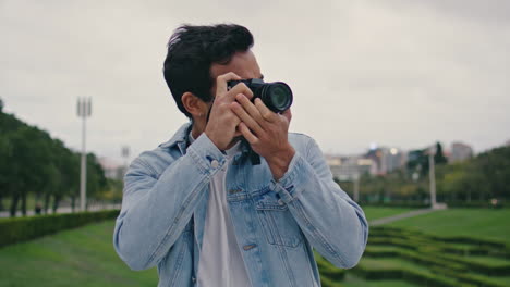 unshaven guy photographing park nature at cloudy spring evening close up.