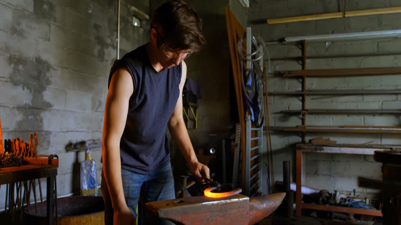 metalúrgico que sostiene una herradura en la fábrica 4k