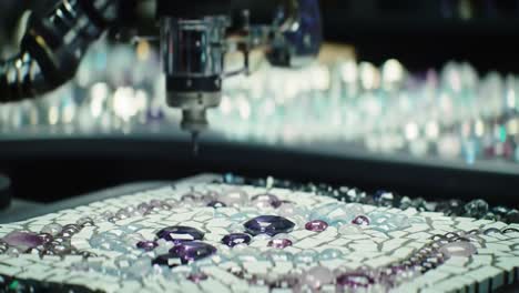 artisans carefully assemble colorful gemstones and tiles into stunning mosaic patterns. the meticulous work takes place in a creative workshop filled with artistic materials.
