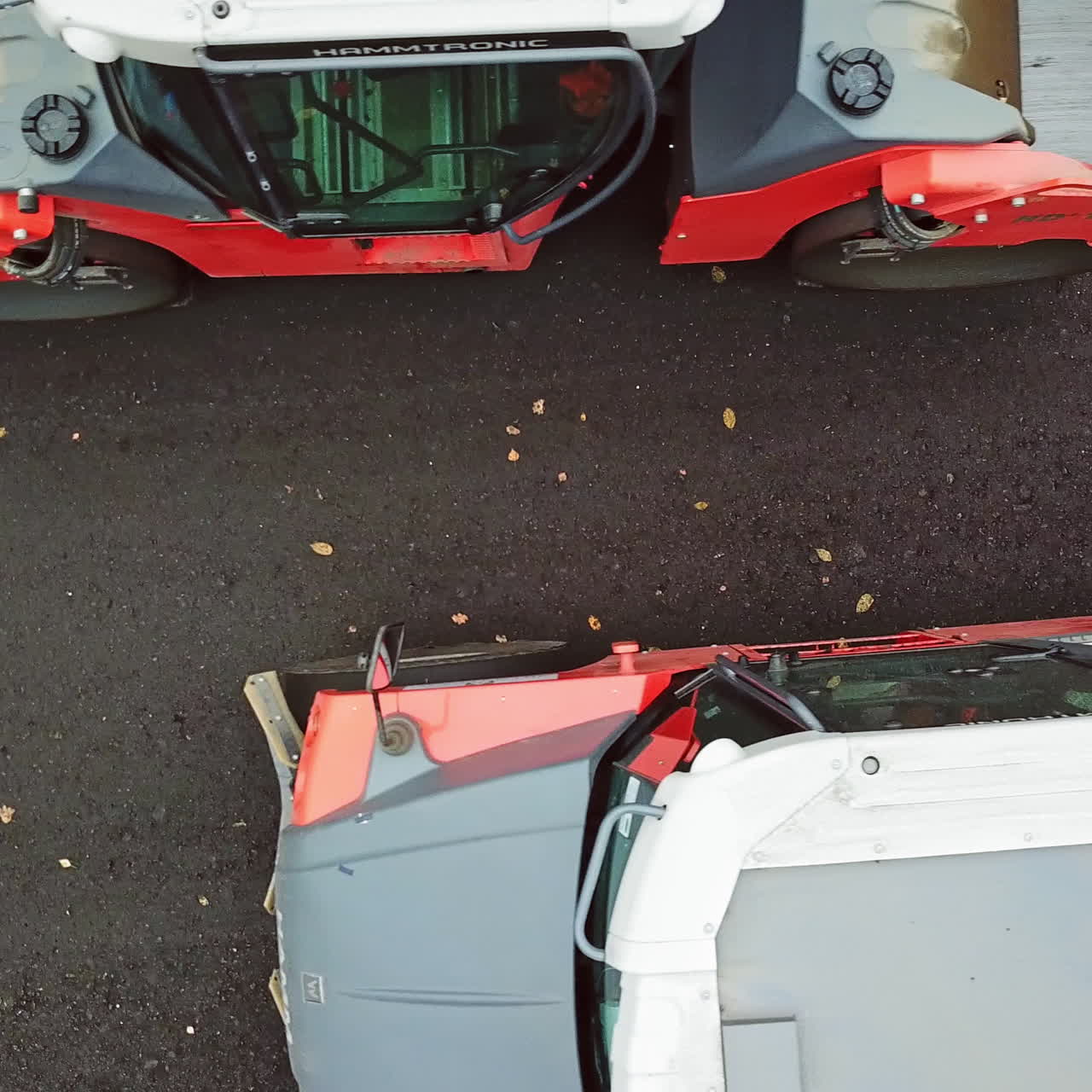 Top view of heavy machinery at roadworks. Two asphalt compactors working on different sides of the road. Camera moves bottom up.